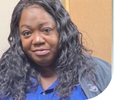 African American woman in blue clothing smiling at camera