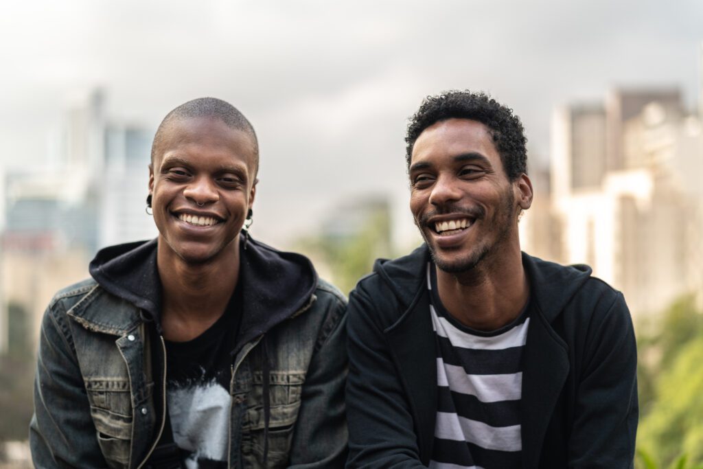 Two latino african men smiling at camera outside